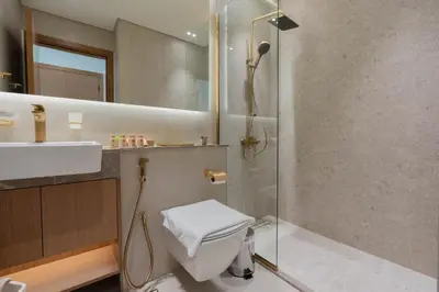 a bathroom with a shower and a toilet and a sink at TRPS - Binghatti Amber, JVC - Luxury 1BR Haven - Prime Location in Dubai