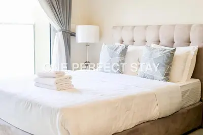 a bedroom with a large bed with a white bedspread at Modern Studio 10 Mints Away From Expo Pool & Gym in Dubai