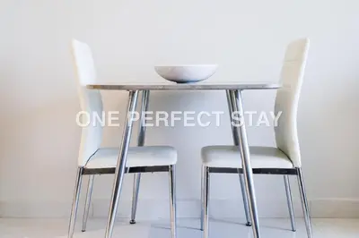 two chairs and a table with a bowl on top at Modern Studio 10 Mints Away From Expo Pool & Gym in Dubai