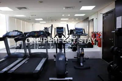 a gym with several tread machines in a room at Modern Studio 10 Mints Away From Expo Pool & Gym in Dubai