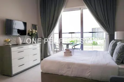 a bedroom with a bed and a large window at Modern Studio 10 Mints Away From Expo Pool & Gym in Dubai