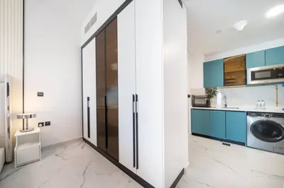 a kitchen with a refrigerator and a washing machine at Modern and Spacious Studio Al Barsha South Stay in Dubai