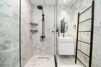 a bathroom with a shower and a sink at Modern and Spacious Studio Al Barsha South Stay in Dubai