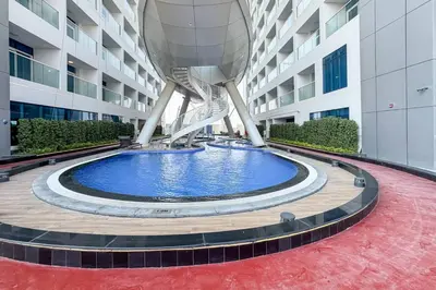 a building with a large pool in front of it at Modern and Spacious Studio Al Barsha South Stay in Dubai