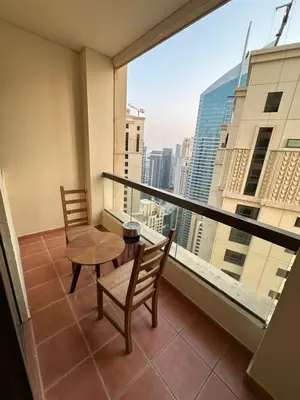 a balcony with a table and chairs and a view at JBR Skyview Rooms in Dubai