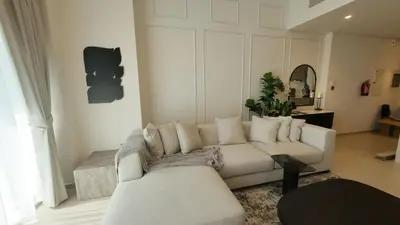 a living room with a white couch and a table at Luxe 1 Bedroom with High Floor close to Dubai Mall in Dubai