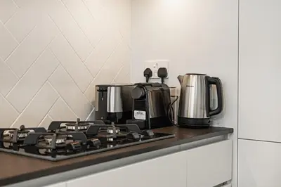 a stove top with a coffee maker on top of it at Furnished 2BR with Vibrant View in Dubai
