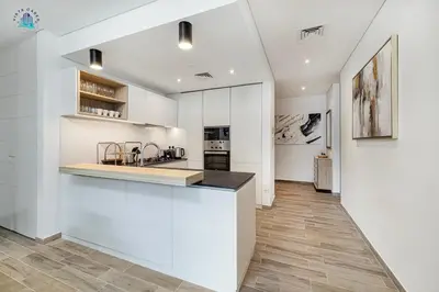 a kitchen with white walls and a counter top at Furnished 2BR with Vibrant View in Dubai