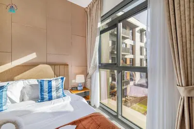 a bedroom with a bed and a large window at Furnished 2BR with Vibrant View in Dubai