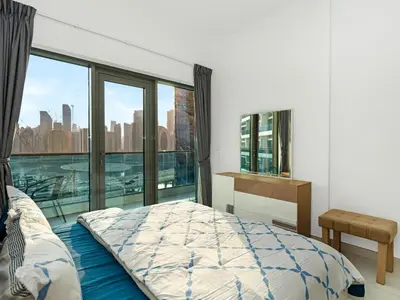a bedroom with a bed and a large window at Luxury 2BR near Burj Khalifa with Rooftop Pool, City & Canal Views, Free Parking in Dubai