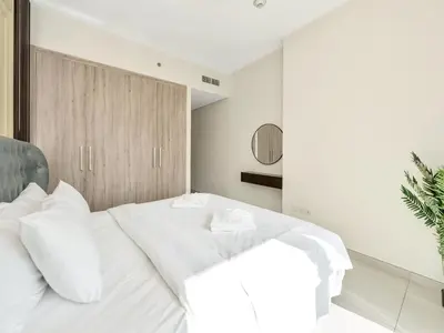a bedroom with a large white bed with white pillows at Luxury 2BR near Burj Khalifa with Rooftop Pool, City & Canal Views, Free Parking in Dubai