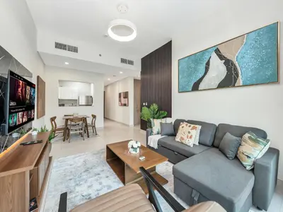 a living room with a couch and a table at Modern 1BR Near Burj Khalifa with Rooftop Pool, City & Canal Views, Free Parking in Dubai