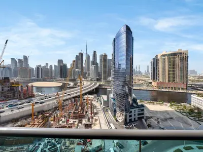 a view of a city with a tall skyscraper at Modern 1BR Near Burj Khalifa with Rooftop Pool, City & Canal Views, Free Parking in Dubai