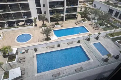 an overhead view of two swimming pools in a building at Luxe Studio Vibes Stylish & All New Pet Free in Dubai