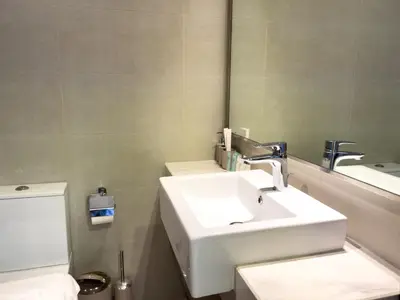 a bathroom with a sink and a toilet and a mirror at Luxe Studio Vibes Stylish & All New Pet Free in Dubai