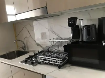 a kitchen counter with a dish drying rack next to a sink at Luxe Studio Vibes Stylish & All New Pet Free in Dubai
