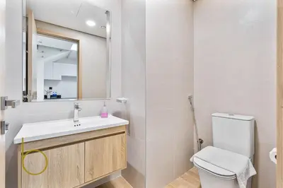 a bathroom with a toilet and a sink and a mirror at Bookable -1 Bed Rukan Townhouse with Clubhouse Access in Dubai
