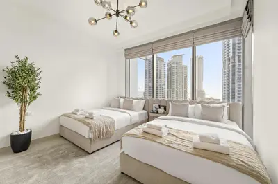 two beds in a room with a large window at Luxe 2BR with Marina Views l Gaming & Music Room in Dubai
