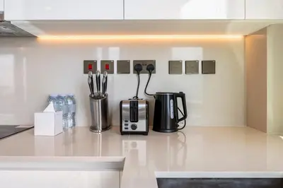 a kitchen counter with a coffee maker and utensils at Iconic 3BHK I Stunning Creek Views I Sleep up to 6 guests I High Floor I Pool I Free Parking I Pet Friendly I in Dubai