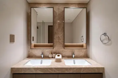 a bathroom with two sinks and two mirrors at Keyrock - Emaar Beachfront Apartment with Sea & Palm Jumeirah Views in Dubai