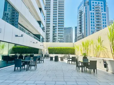 a patio with tables and chairs in a building at Luxurious 1BR , Damac Maison Canal Views in Dubai