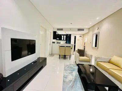 a living room with a flat screen tv and a couch at Luxurious 1BR , Damac Maison Canal Views in Dubai