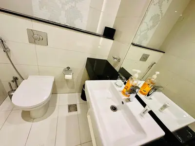 a bathroom with a white sink and a toilet at Luxurious 1BR , Damac Maison Canal Views in Dubai