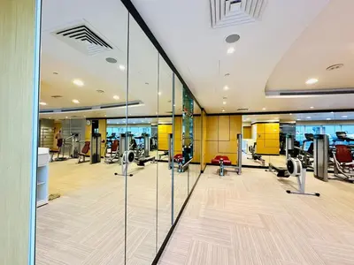 a gym with treadmills and elliptical machines at Luxurious 1BR , Damac Maison Canal Views in Dubai