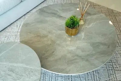 a round concrete table with a potted plant on it at KeyRock - Dreamy Stay with Palm View - Emaar Beach in Dubai