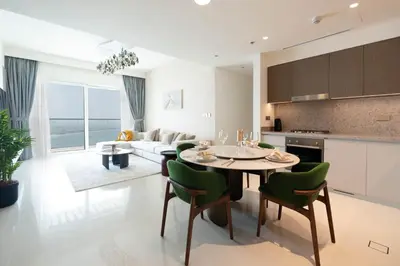 a kitchen and living room with a table and chairs at KeyRock - Dreamy Stay with Palm View - Emaar Beach in Dubai