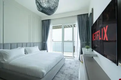 a bedroom with a white bed and a large window at KeyRock - Dreamy Stay with Palm View - Emaar Beach in Dubai