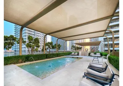 a swimming pool with chairs and a building at KeyRock - Dreamy Stay with Palm View - Emaar Beach in Dubai