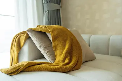a yellow blanket sitting on top of a couch at KeyRock - Dreamy Stay with Palm View - Emaar Beach in Dubai