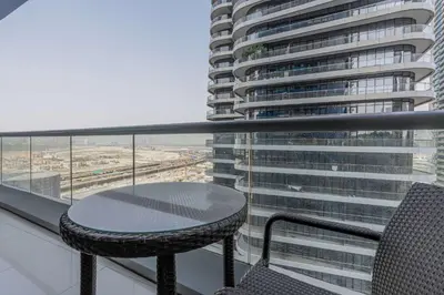 a table and chair on the balcony of a building at TRPS - Maison Mall Street, Downtown - Beautifully Appointed 1BR, Near to Burj Khalifa in Dubai