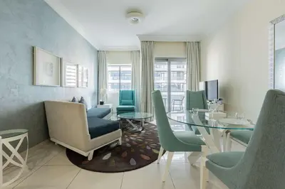 a dining room with a glass table and chairs at TRPS - Maison Mall Street, Downtown - Beautifully Appointed 1BR, Near to Burj Khalifa in Dubai