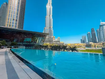 a large swimming pool with a city skyline in the background at Exclusive Burj Khalifa View Luxury 2BR Next to Dubai Mall - Like Home in Dubai