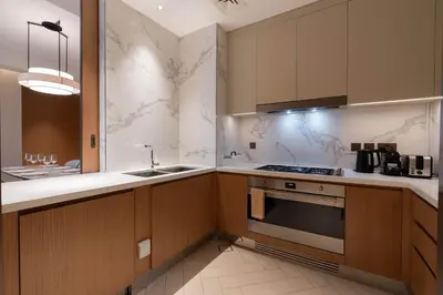 a kitchen with a sink and a stove top oven at TRPS - Address Opera, Downtown - Burj Khalifa View, Luxury 3BR Living in Dubai