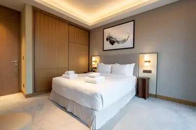 a bedroom with a large white bed with towels on it at TRPS - Address Opera, Downtown - Burj Khalifa View, Luxury 3BR Living in Dubai