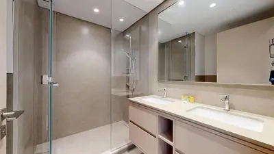 a bathroom with a sink and a glass shower at Panaromic Burj Khalifa View from Balcony - Luxury 2BR next to Dubai Mall - Like Homes in Dubai