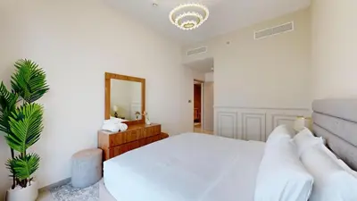 a bedroom with a large white bed and a mirror at Panaromic Burj Khalifa View from Balcony - Luxury 2BR next to Dubai Mall - Like Homes in Dubai