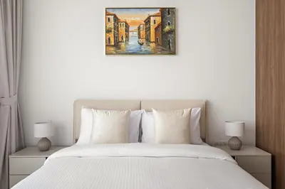 a bedroom with a bed and a painting on the wall at Stylish 1BR in Hamilton House in Dubai