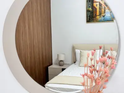 a mirror in a bedroom with a bed and flowers at Stylish 1BR in Hamilton House in Dubai