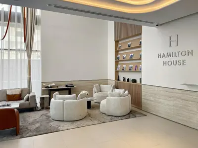 a lobby with white chairs and a million house sign at Stylish 1BR in Hamilton House in Dubai