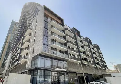 a tall building with glass windows on a city street at Stylish 1BR in Hamilton House in Dubai