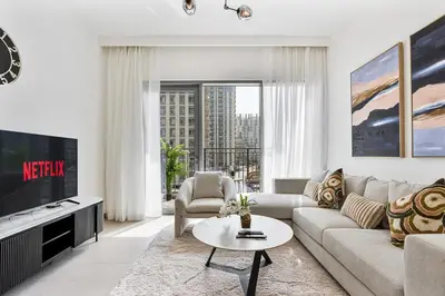 a living room with a couch and a tv at Radiant 2BR APT near Dubai Hills Park & Golf Club in Dubai