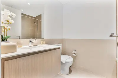 a bathroom with a toilet and a sink and a mirror at Radiant 2BR APT near Dubai Hills Park & Golf Club in Dubai