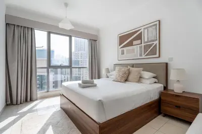 a bedroom with a large bed and a large window at GuestReady - Downtown View | 1BR + Sofa Bed in Dubai