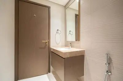 a bathroom with a sink and a wooden door at KeyRock - Palm View Luxury Stay in Grand Bleu in Dubai