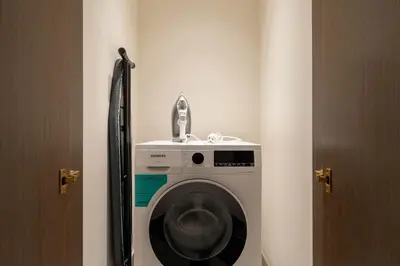 a washing machine in a room next to a door at KeyRock - Palm View Luxury Stay in Grand Bleu in Dubai