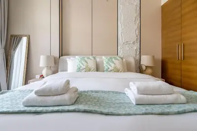 a bedroom with a white bed with towels on it at DAYF-CLA Stylish Apartment for 4 Guests in Central Location in Dubai